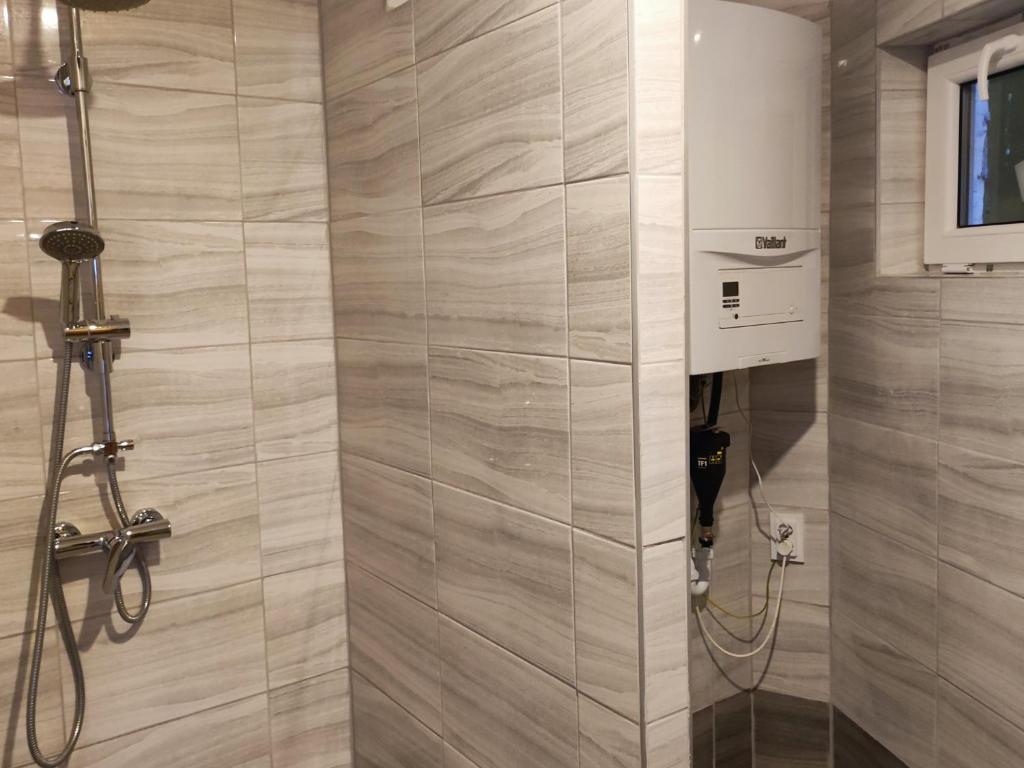een badkamer met douche bij Váralja Vendégház in Tata