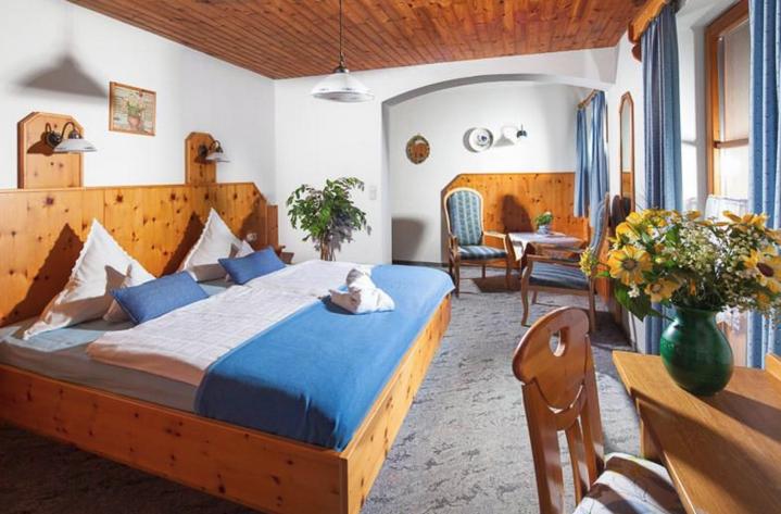 - une chambre avec un grand lit en bois dans l'établissement Pension Rennlehen, à Berchtesgaden