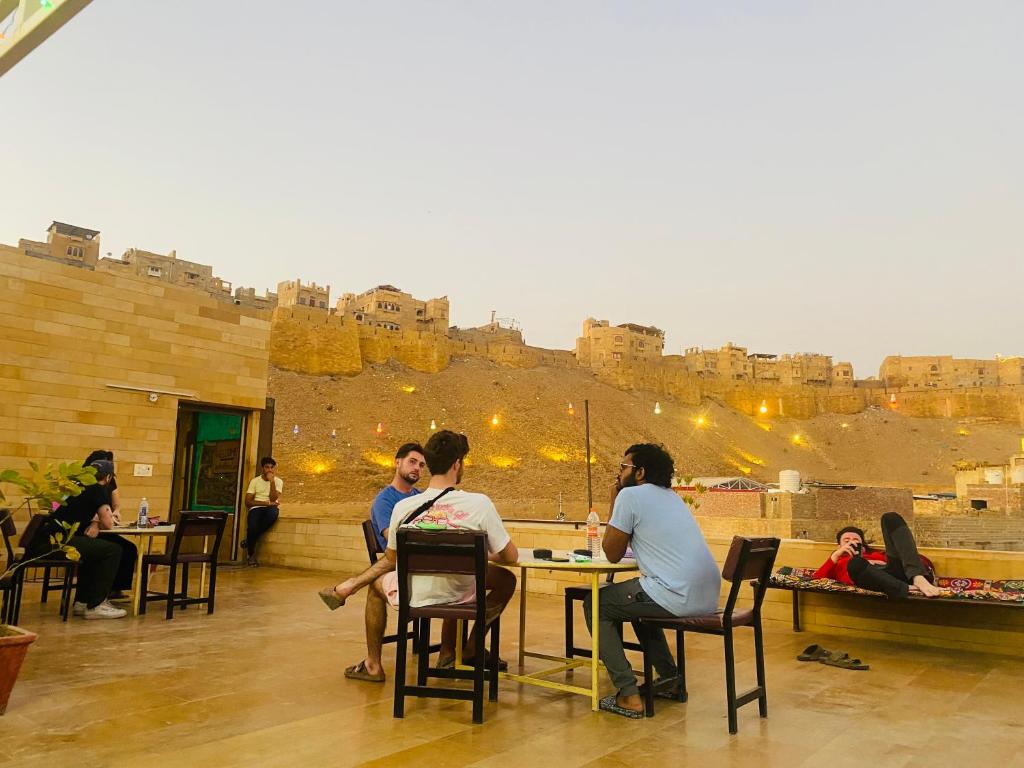 un gruppo di persone seduti ai tavoli di fronte a un castello di Wonbin Safari Jaisalmer a Jaisalmer