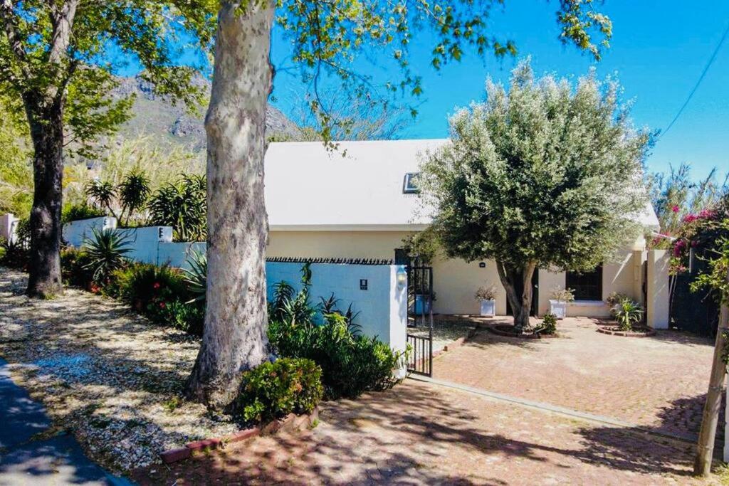 a house with a white garage and trees at The Olive Tree Cottage in Riebeek-Wes