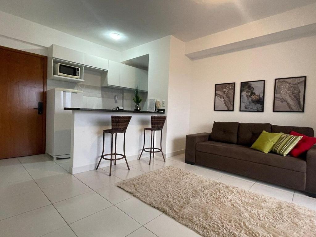 sala de estar con sofá y cocina en Apartamento Studio lado do Hospital Premium ST2203, en Goiânia
