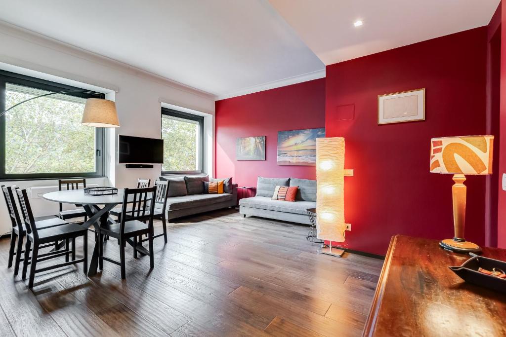 Hotel Music Bridge Apartment, a living room with red walls and a table and chairs at Music Bridge Apartment in Rome