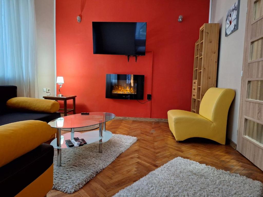 a living room with a red wall with a fireplace at Cozy apartment in the heart of Sofia in Sofia