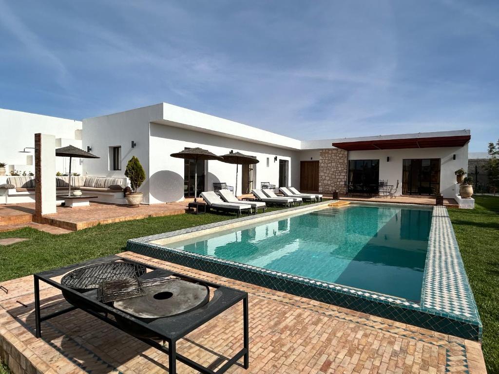 Villa Essaouira petit déjeuner compris في الصويرة: مسبح في ساحة منزل