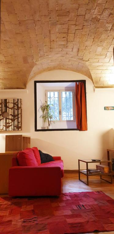 ローマにあるCharming Loft Trastevereのリビングルーム(赤いソファ、窓付)