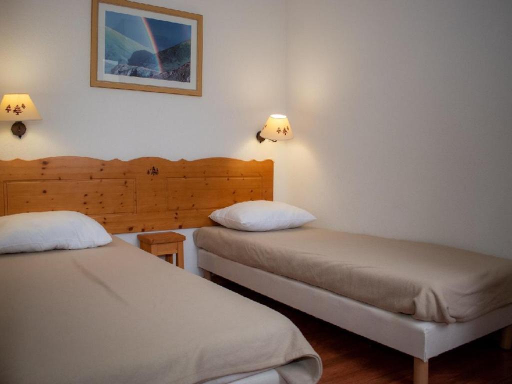 - 2 lits dans une chambre avec 2 lampes sur le mur dans l'établissement 2 Pièces 4 Pers., Ski, Cuisine Équipée, Animaux Permis, Parking - FR-1-504-561, à Superdevoluy