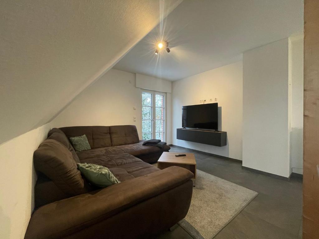 a living room with a couch and a flat screen tv at Monteurwohnung Villa Waffi in Bippen