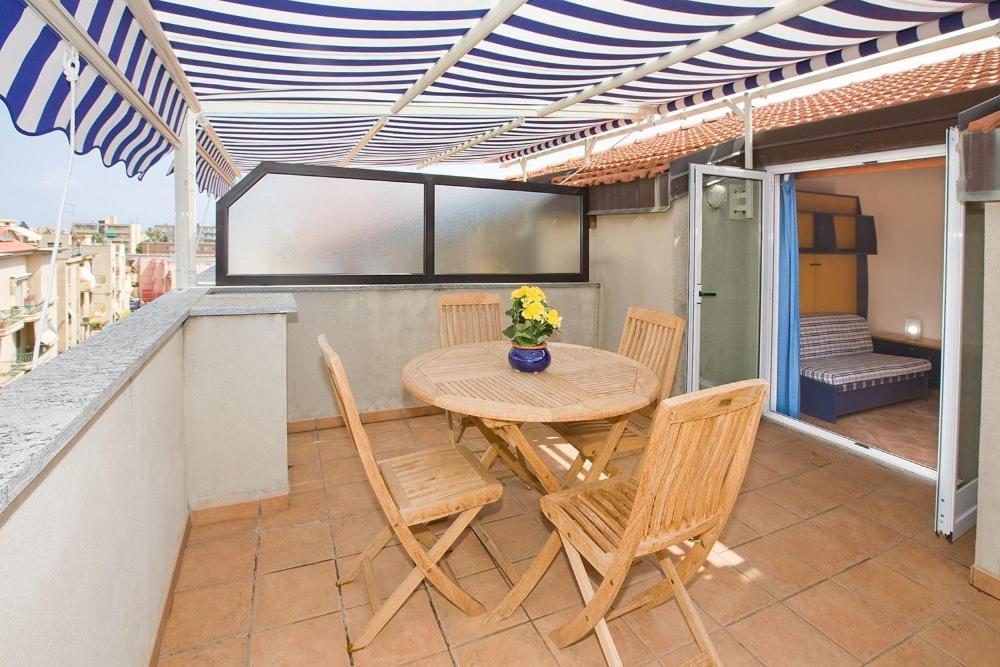 a wooden table and chairs on a balcony at Residenza Adelaide in Finale Ligure