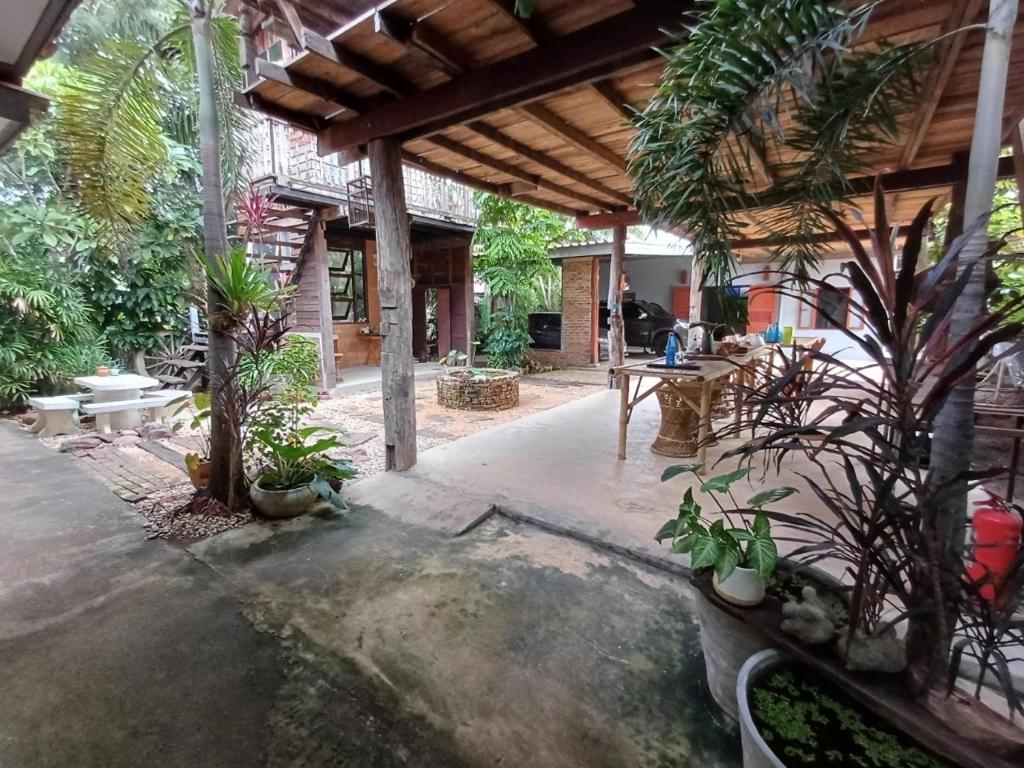 een patio met een bos planten en een tafel bij Baan Mali Lampang Homestay in Lampang