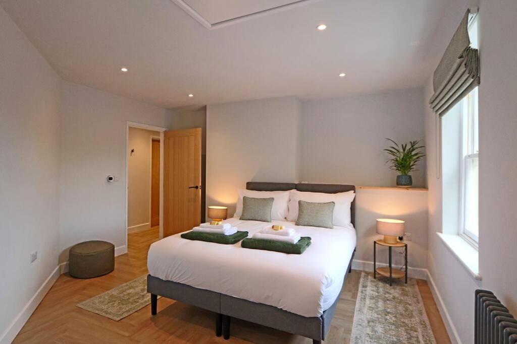 una camera da letto con un grande letto bianco con due lampade di Luxurious Modern Retreat a Melbourne