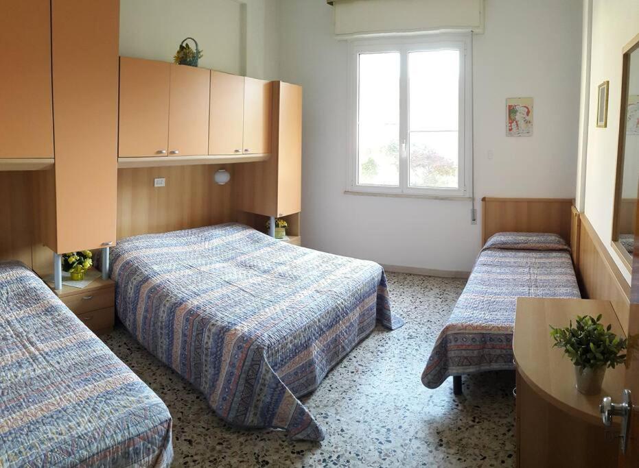 een hotelkamer met 2 bedden en een raam bij Appartamento ROYAL in Gatteo a Mare