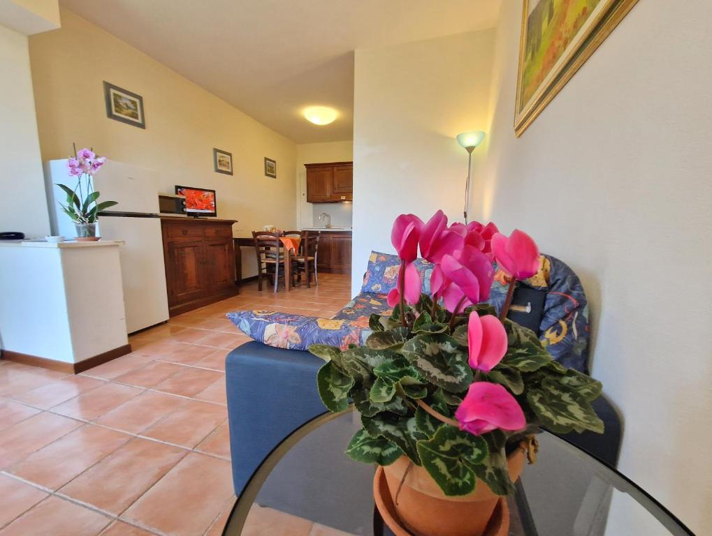 a living room with a vase with pink flowers on a table at Residence Le Meridiane in Siena