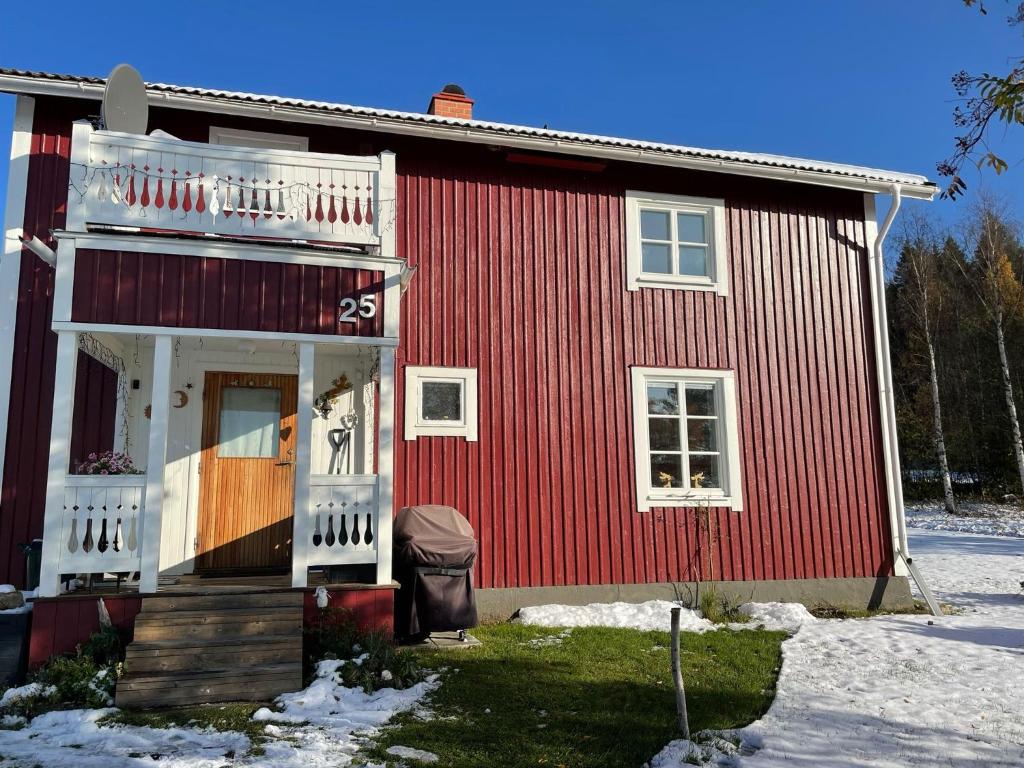 Villa Avaborg في Burträsk: منزل احمر مع شرفة