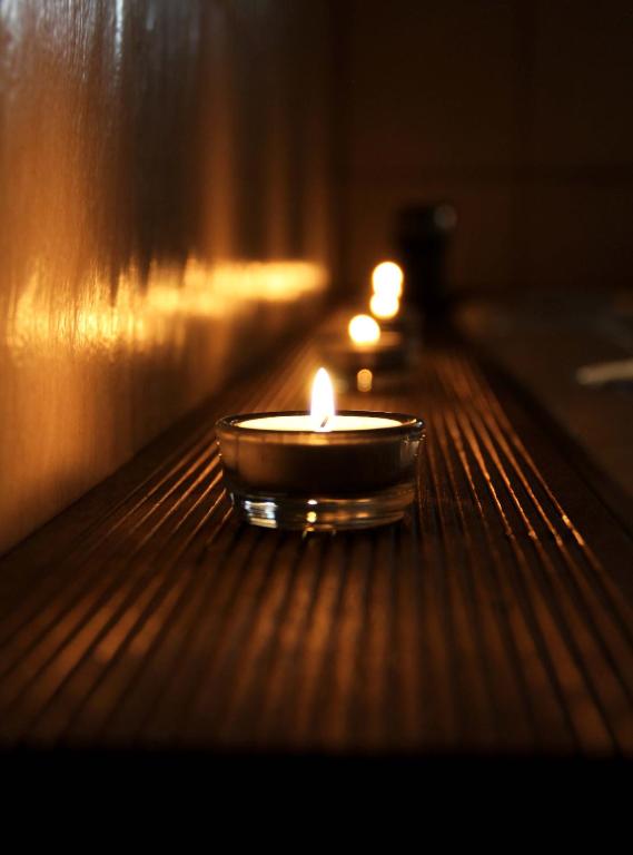 a candle in a bowl sitting on a table at Penzion Dori in Diakovce