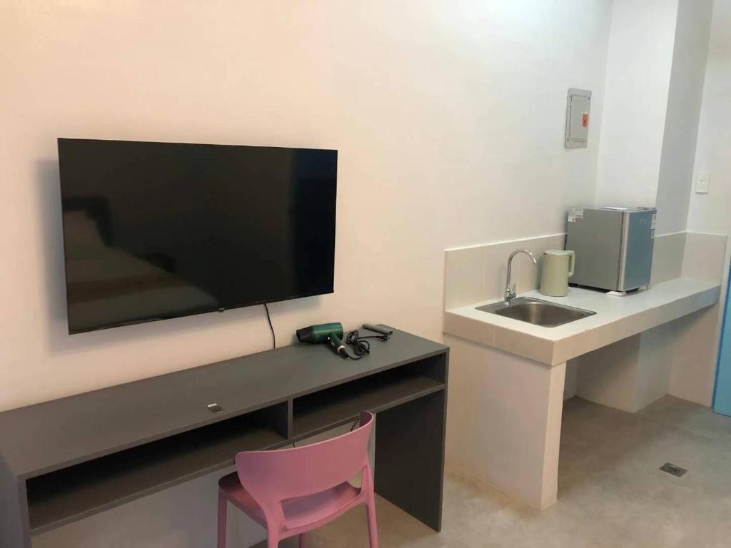 a bathroom with a sink and a flat screen tv at COCO STAR HOTEL in Manila