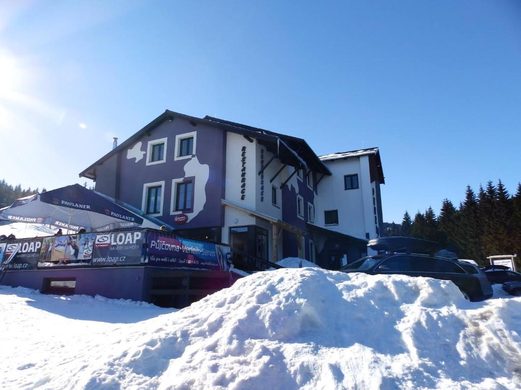 a pile of snow in front of a building at Pension Max Klínovec in Loučná pod Klínovcem