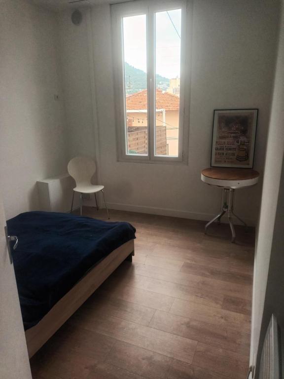a bedroom with a bed and a desk and a window at Charmant et cosy 4 pcs in Nice