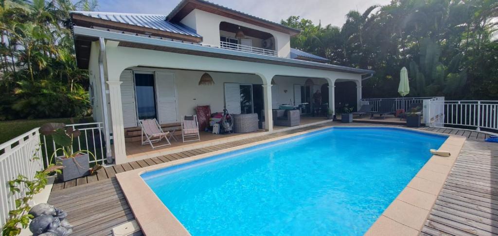 uma casa com piscina num deque em Les oliviers sous le cocotier em Saint-Joseph