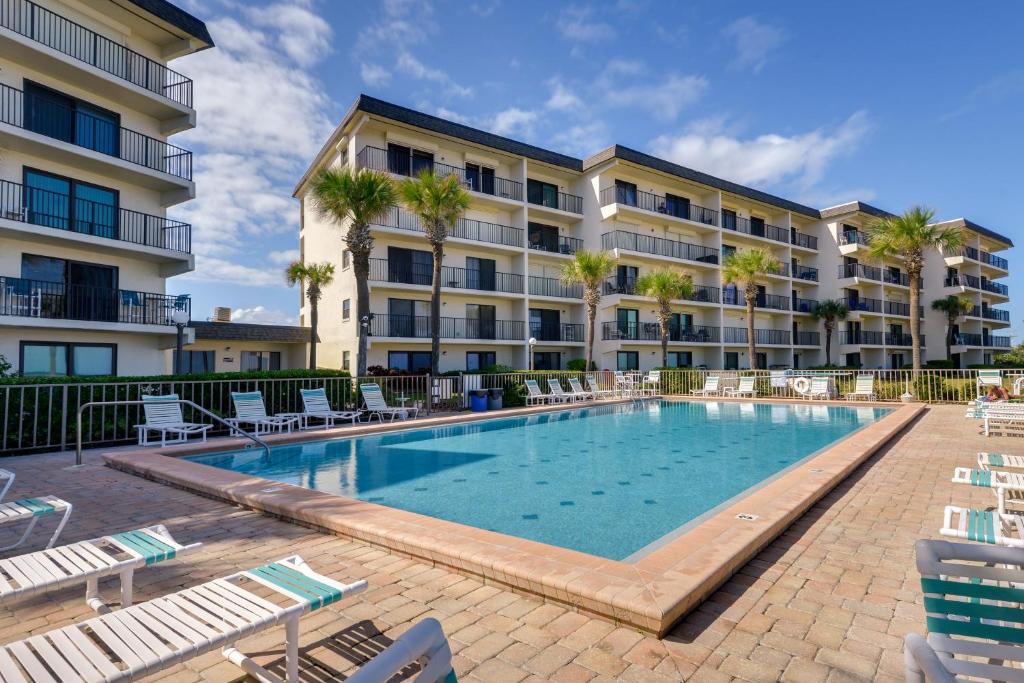 a swimming pool in front of a building at Oceanfront Ormond Beach Condo Community Perks! in Ormond Beach