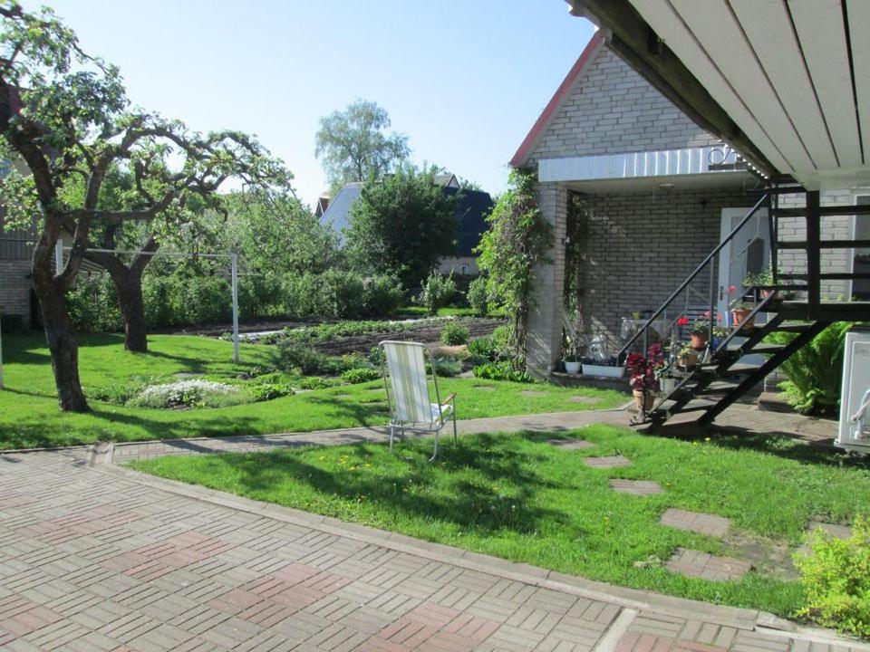 un patio con un banco en el césped en Mary`s villa, en Pärnu