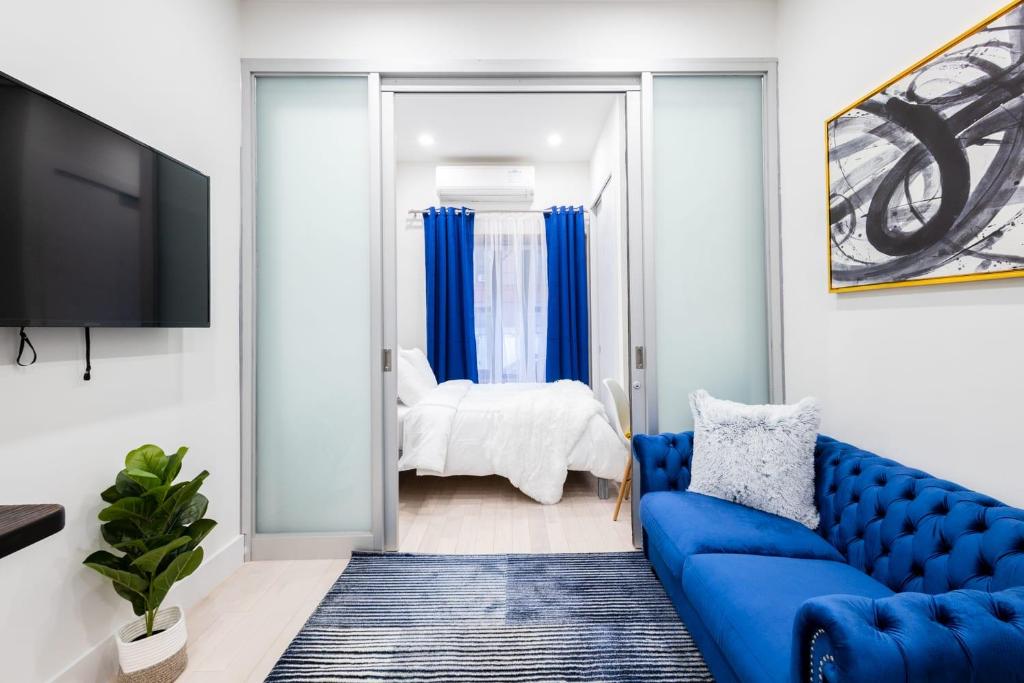 un salon avec un canapé bleu et une chambre dans l'établissement 317-1AN - New Modern 1BR W&D Walk to Central Park, à New York