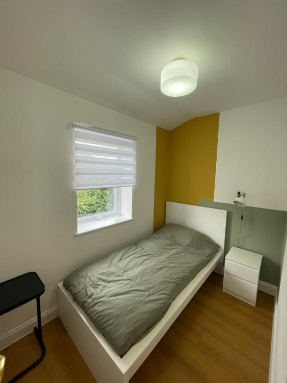 a small bedroom with a bed and a window at Stunning house in Anfield, whole house in Liverpool