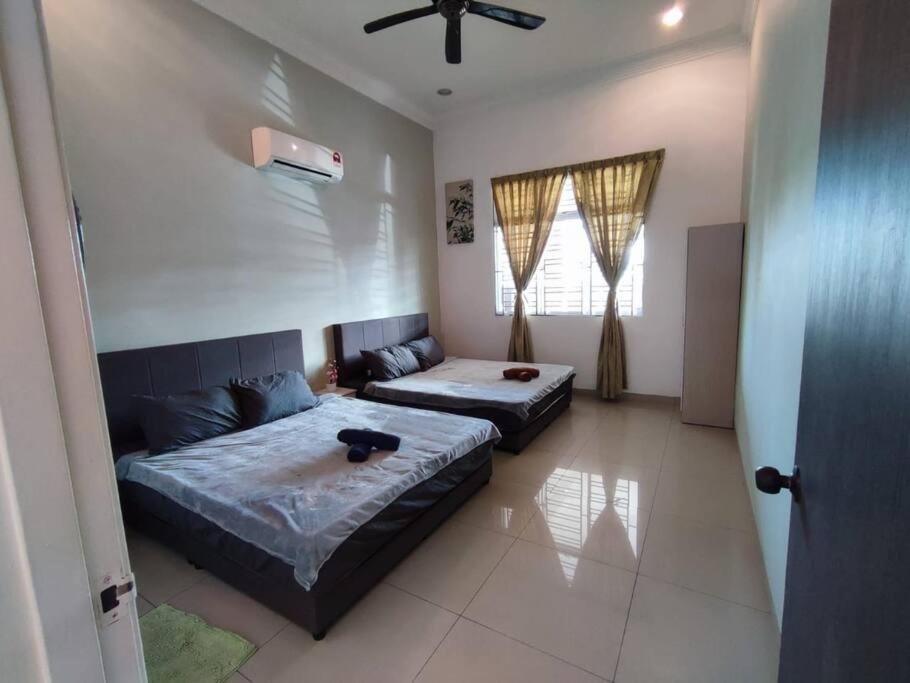una camera con 2 letti e un ventilatore a soffitto di Sayang-Sayang Homestay $CRAZY OFFER$ 4R2B a Batu Pahat
