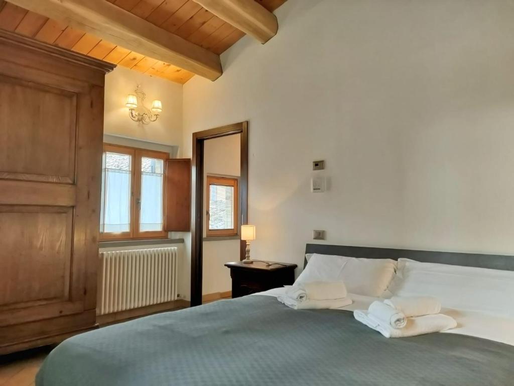 1 dormitorio con 1 cama con 2 toallas en Appartamento Sotto i Torricini, en Urbino