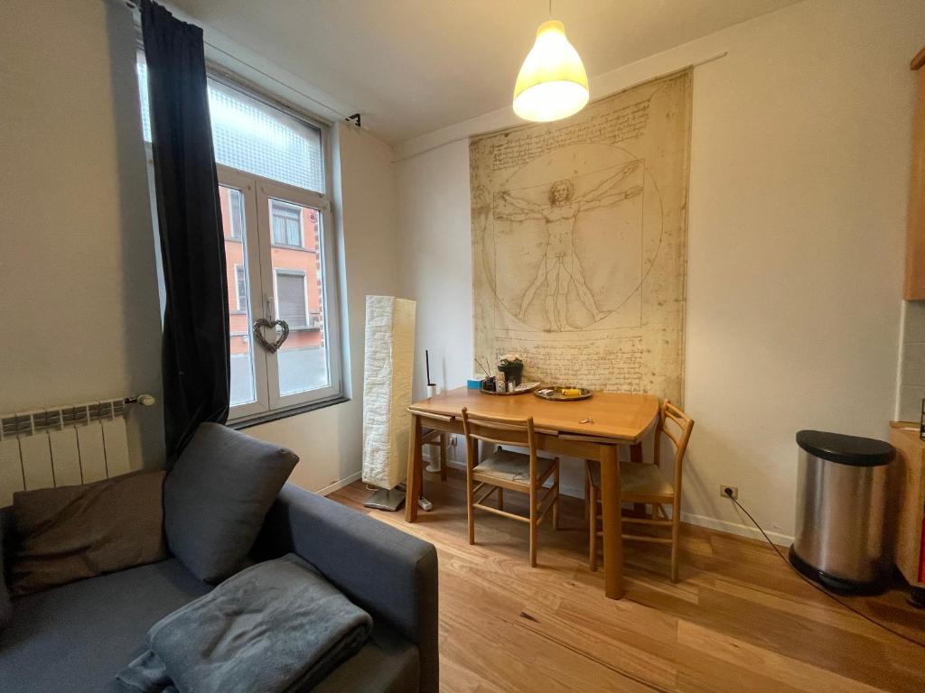 ein Wohnzimmer mit einem Tisch und einem Sofa in der Unterkunft Appartement spacieux pour un séjour inoubliable in Brüssel