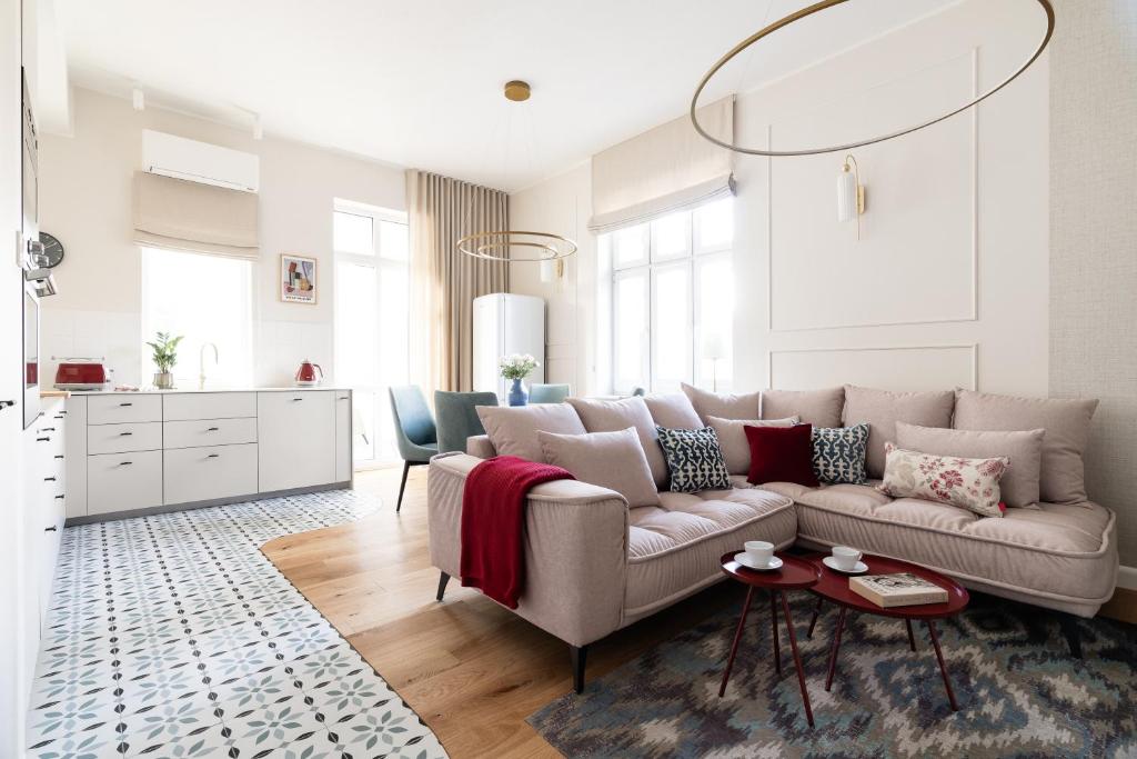 ein Wohnzimmer mit einem Sofa und einem Tisch in der Unterkunft Sanhaus Apartments - Apartament Santorini - dwie sypialnie, dwie łazienki, klimatyzacja in Sopot