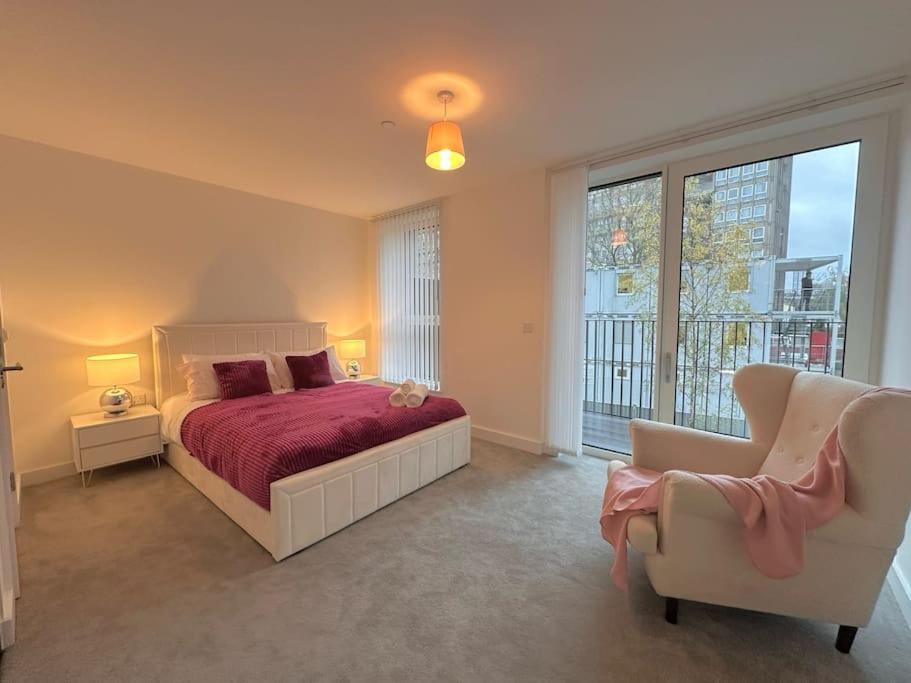 倫敦的住宿－Glitz and Luxury，一间卧室配有一张床、一张沙发和一把椅子