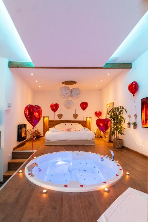 Cette chambre comprend un lit avec des ballons à cœur rouge. dans l'établissement L'escapade Romantique, à Dreuil-lès-Amiens
