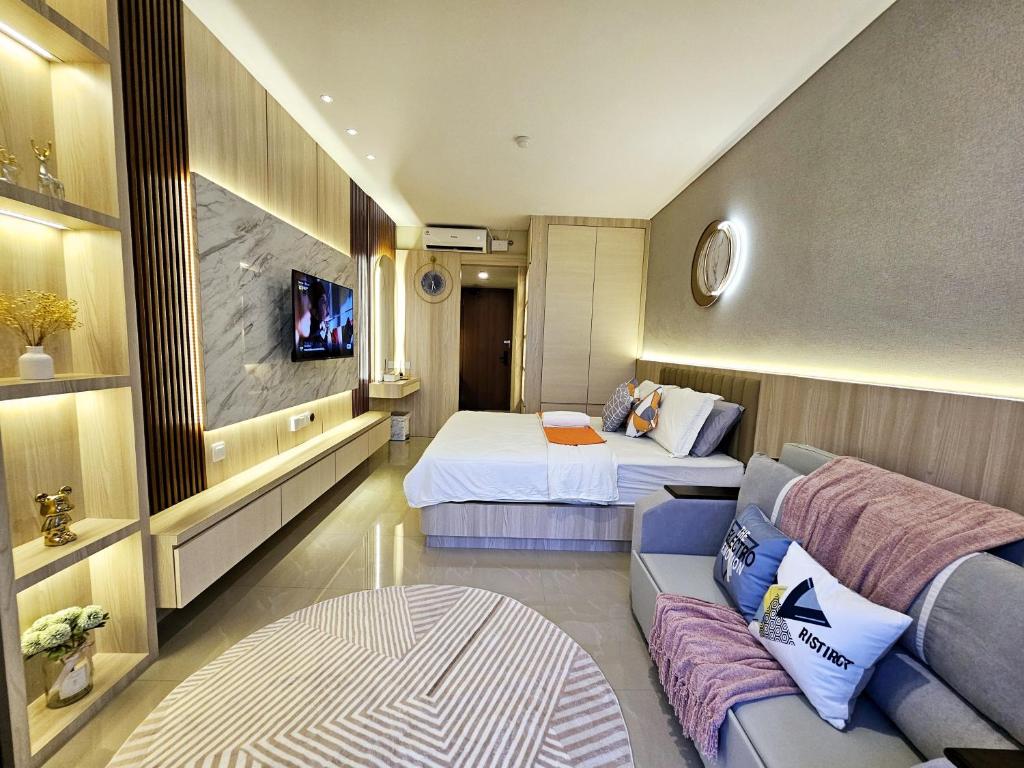 une chambre d'hôtel avec deux lits et un canapé dans l'établissement Nagoya Thamrin City Apartment Tower A, à Nagoya