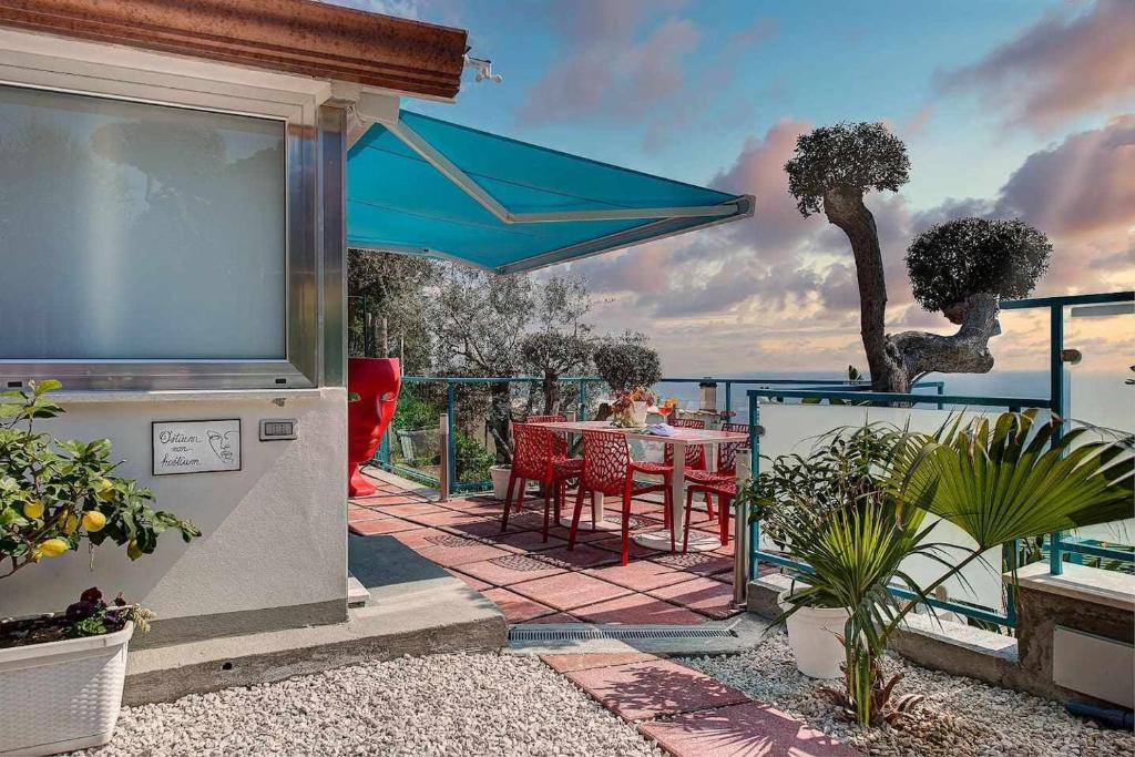 une terrasse avec une table et un parasol bleu dans l'établissement Villa Islamorada Pool and Sea View, à Massa Lubrense