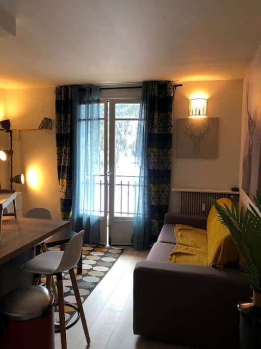 un salon avec un canapé et une fenêtre dans l'établissement Bienvenue chez Celia et Nicolas, à Saint-Étienne-de-Tinée