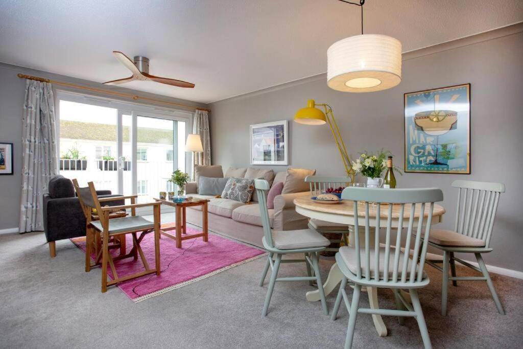 a living room with a table and a couch at Western Court Sidmouth close to town and beach in Sidmouth