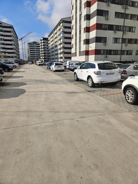 una fila de autos estacionados en un estacionamiento en Robik Studio Militari Residence en Roşu