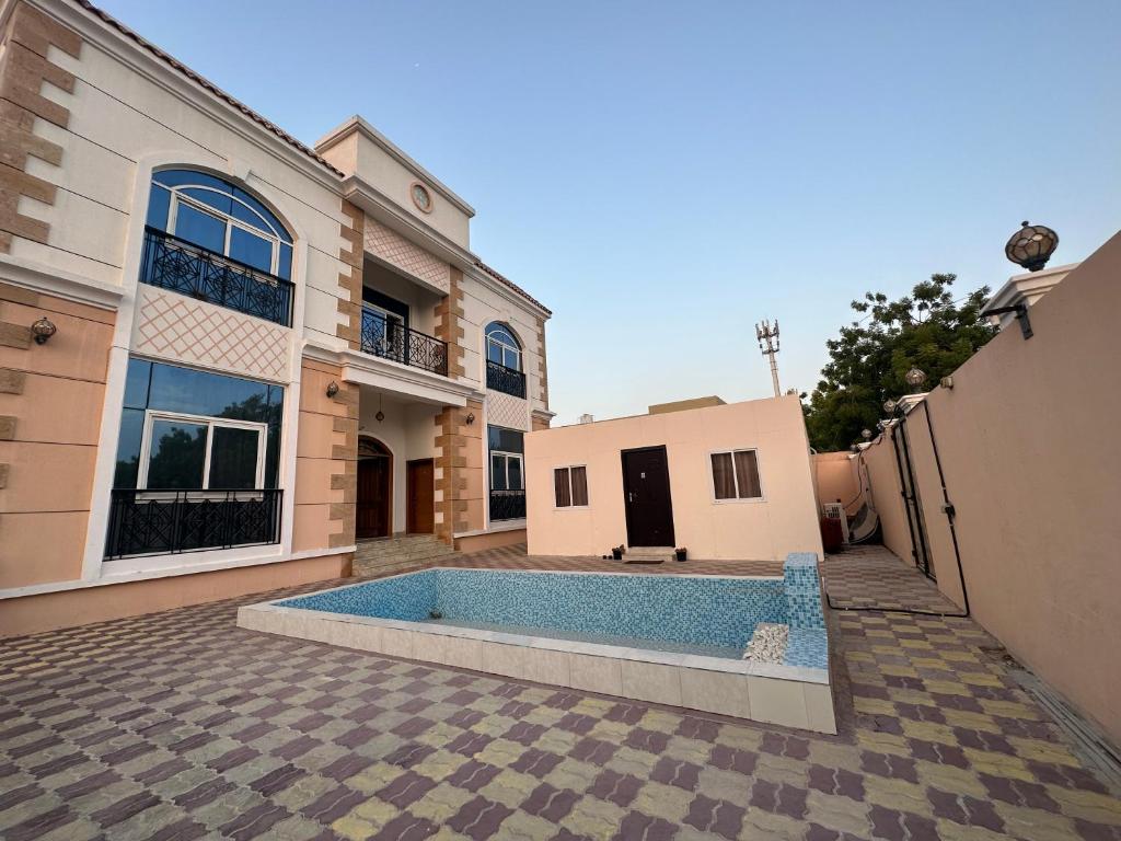 a house with a swimming pool in the yard at Small single room inside luxurious villa in Dubai
