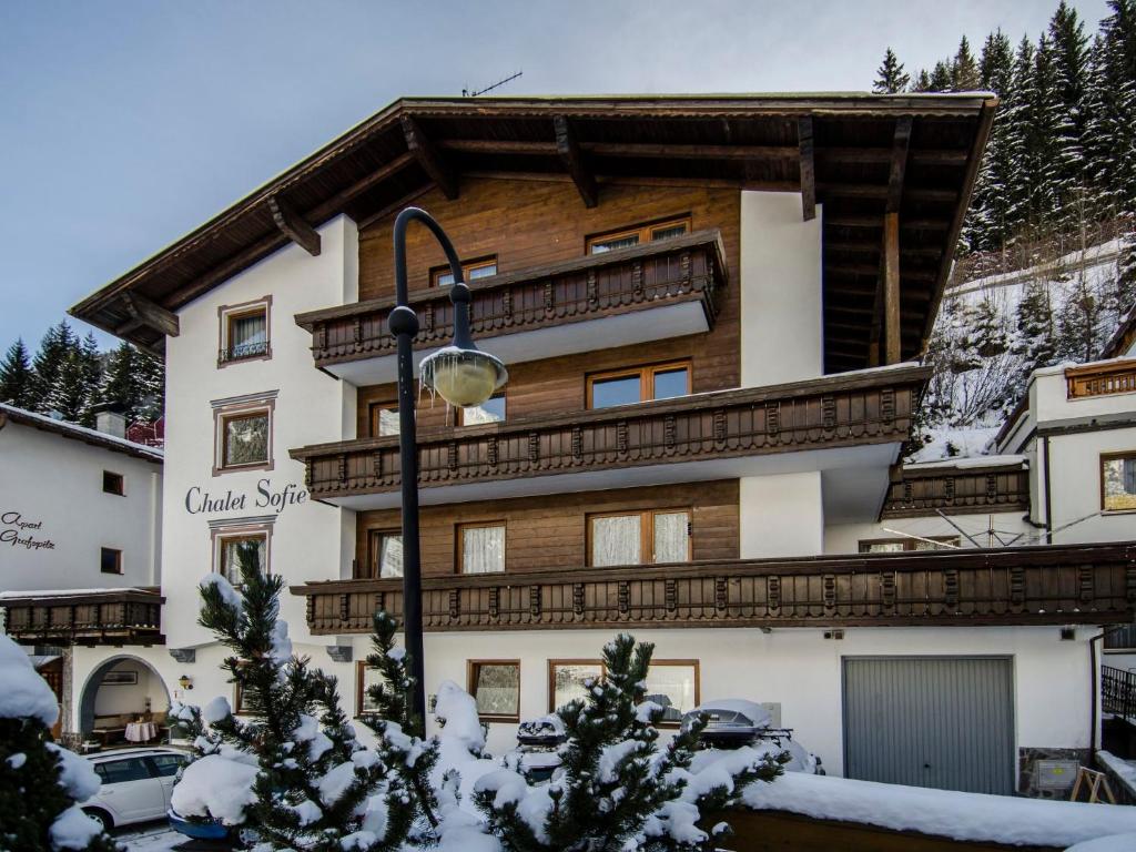 a building in the snow with cars parked in front at Apartment Top 5 by Interhome in Ischgl