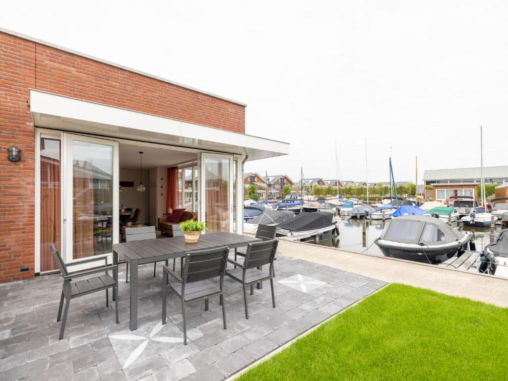 a patio with a table and chairs and a marina at Holiday Home De Meerparel by Interhome in Uitgeest