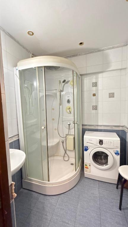 a shower in a bathroom with a washing machine at Квартира посуточно in Almaty