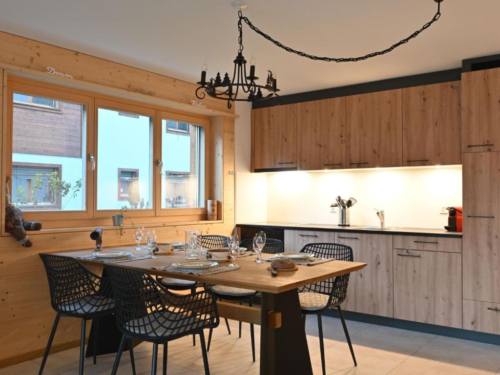 une salle à manger avec une table et des chaises dans une cuisine dans l'établissement Apartment Clos de Morthey A R 01 by Interhome, à Ovronnaz