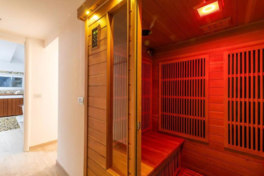 een sauna met een rode muur en een rode bank bij [Moscova - Garibaldi] Lusso, Sauna e Idromassaggio in Milaan