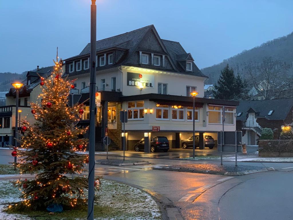 ein Weihnachtsbaum vor einem großen Gebäude in der Unterkunft Stumbergers Hotel in Cochem