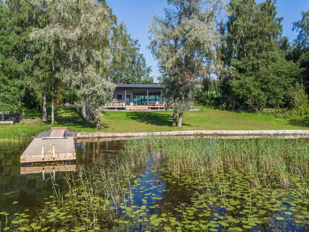 a view of a pond with a building in the background at Holiday Home Villa aura by Interhome in Pälkäne