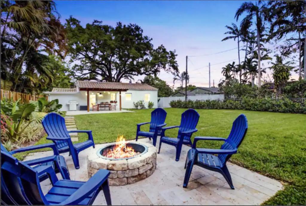 un gruppo di sedie blu intorno a un focolare di Madrinas Cozy Three Bedroom One Bath with Spacious Backyard a Fort Lauderdale