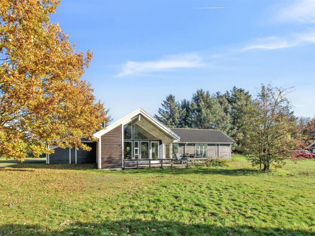 una casa en un campo de hierba con un árbol en Holiday Home Fredrike - all inclusive - 500m from the sea by Interhome en Vester Sømarken