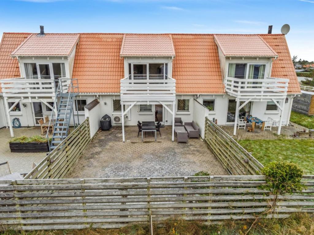 una casa con techo naranja y patio en Apartment Annica - 900m from the sea in NW Jutland by Interhome, en Blokhus