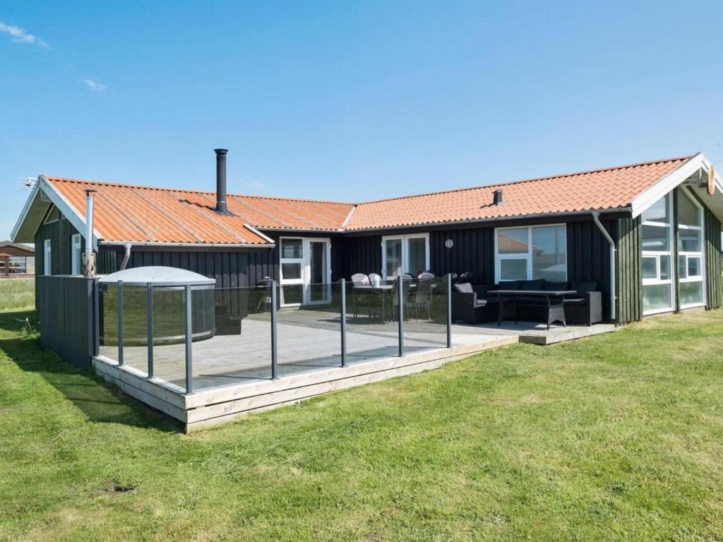 een huis met een terras ervoor bij Holiday Home Månviva - 500m from the sea in NW Jutland by Interhome in Løkken