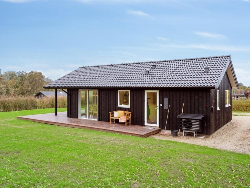 une maison noire avec une terrasse et un grill dans l'établissement Holiday Home Francis - all inclusive - 380m from the sea by Interhome, à Frørup
